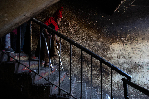 Woman walking down stairs with the assistance of crutches