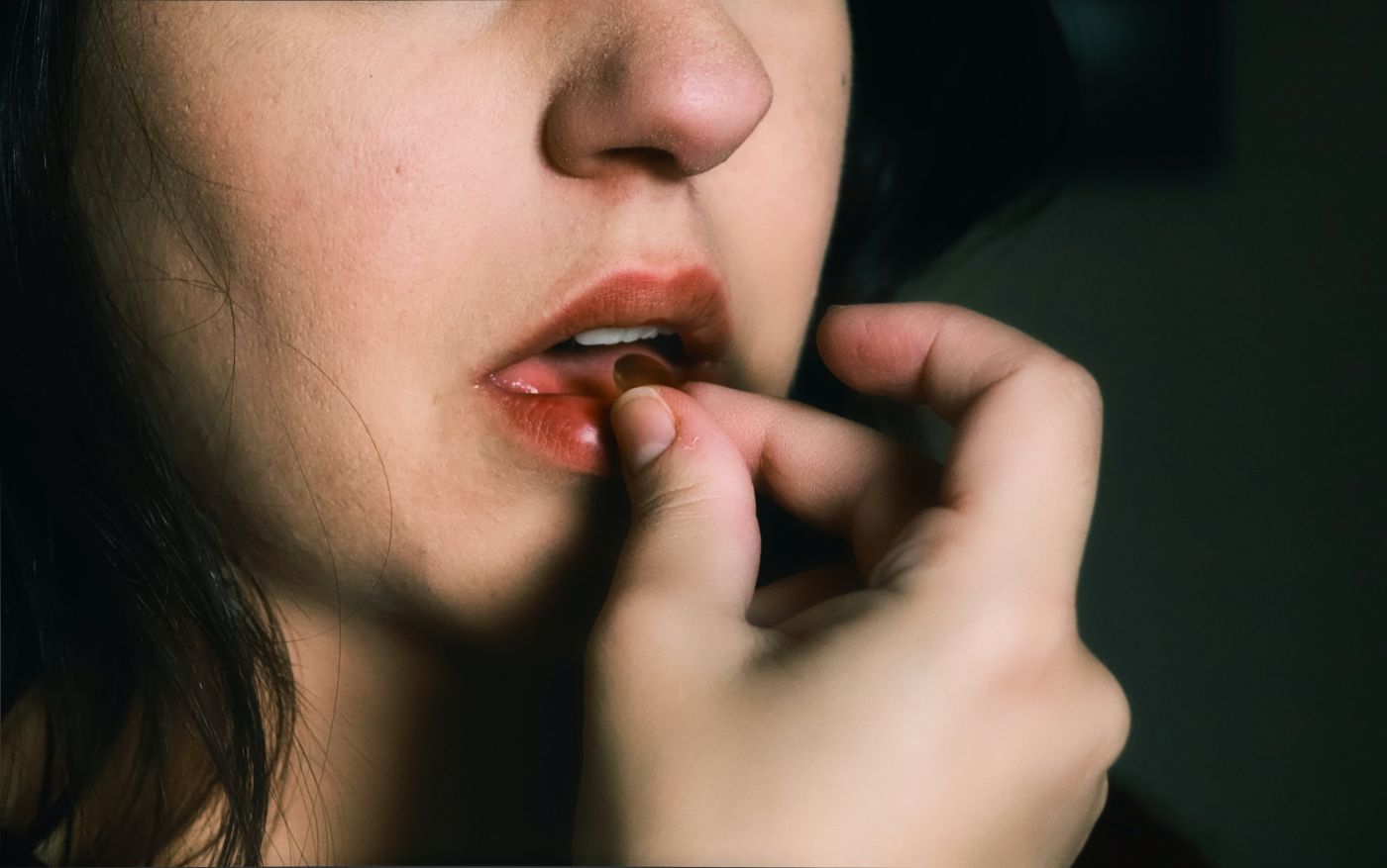 Woman placing a tablet in her mouth