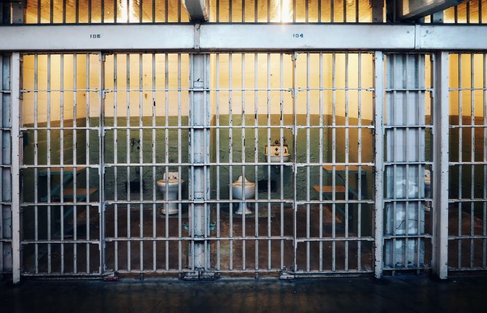 A sink and two toilets within a prison cell